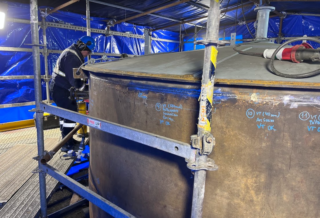 Inspector realizando una evaluación de soldaduras en un estanque industrial